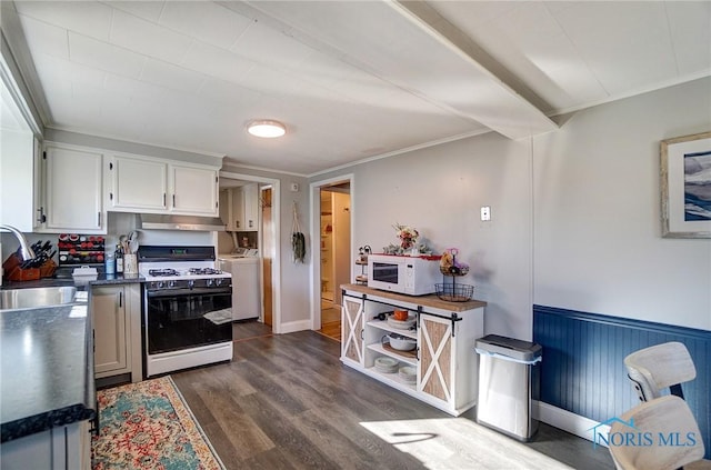 kitchen featuring ornamental molding, dark wood-style flooring, separate washer and dryer, white appliances, and a sink