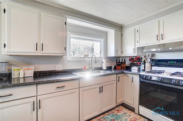 kitchen with under cabinet range hood, range with gas stovetop, white cabinets, and a sink