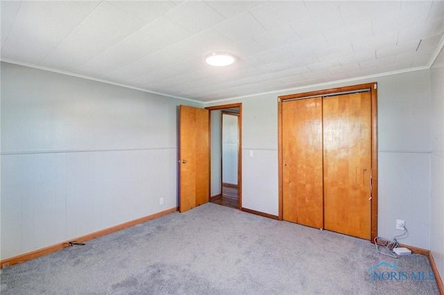 unfurnished bedroom with carpet, a closet, and ornamental molding