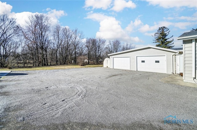 exterior space with a detached garage and an outbuilding