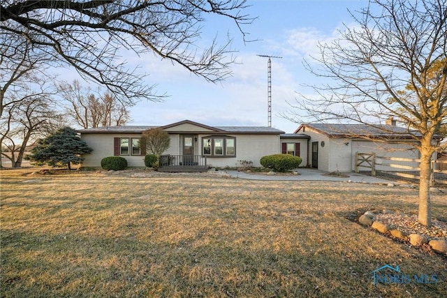 view of front facade with a front lawn and fence