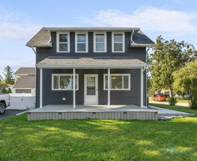 view of front of house with a front yard, a porch, fence, and driveway