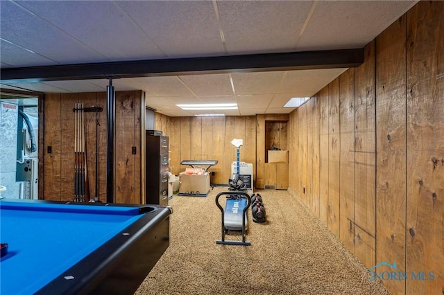 playroom featuring a paneled ceiling, carpet floors, and wood walls