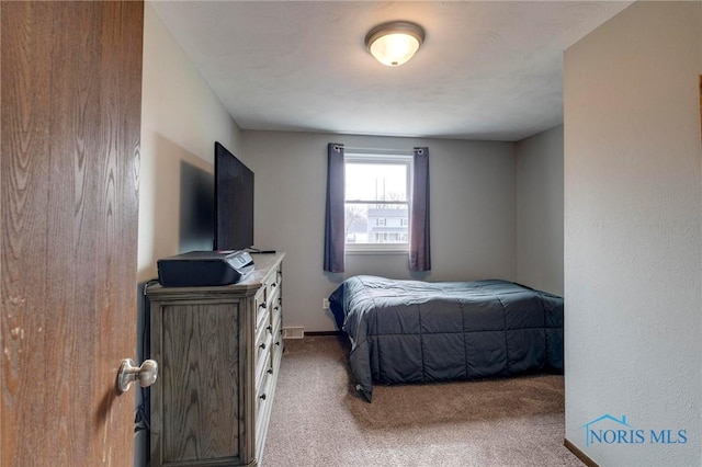 bedroom with baseboards and carpet