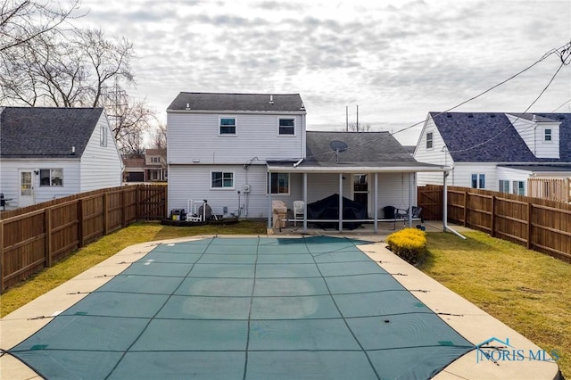 rear view of property with a patio area, a lawn, a fenced in pool, and a fenced backyard