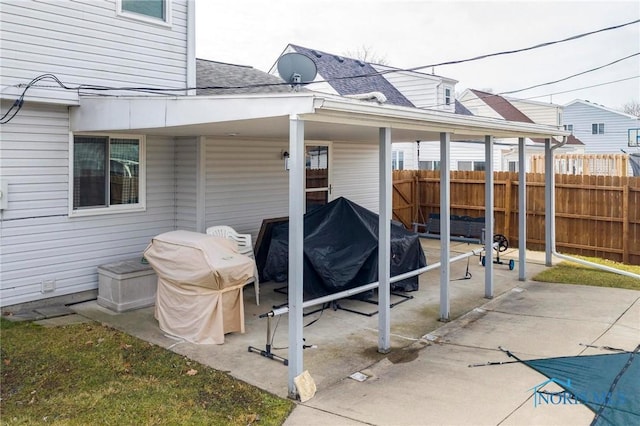 exterior space featuring a patio, roof with shingles, and fence