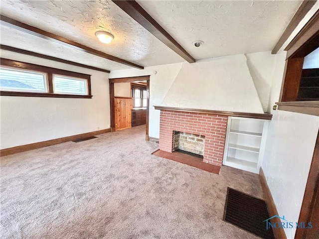 unfurnished living room featuring visible vents, beam ceiling, a textured ceiling, a fireplace, and carpet flooring