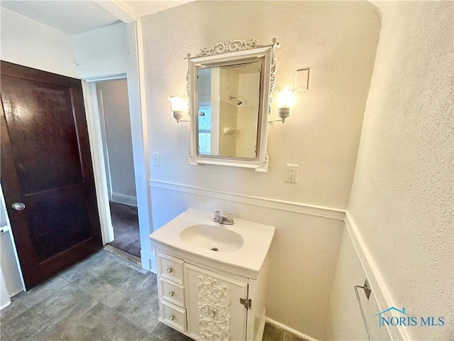 bathroom featuring vanity and a textured wall