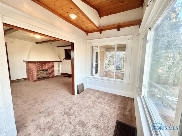 unfurnished living room with visible vents, wooden ceiling, carpet flooring, baseboards, and a brick fireplace