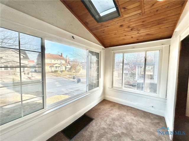 unfurnished sunroom featuring visible vents, vaulted ceiling with skylight, and wooden ceiling