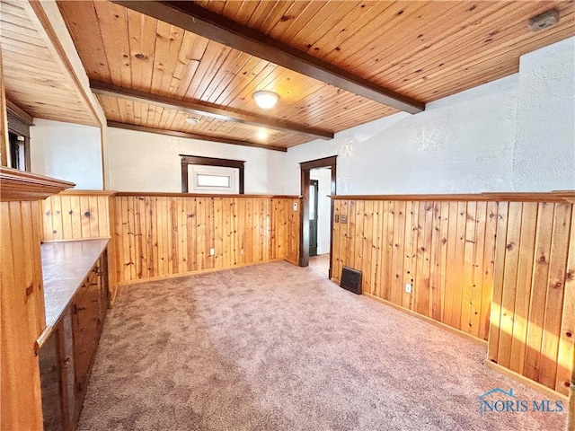 additional living space featuring beam ceiling, a wainscoted wall, wood walls, and wooden ceiling