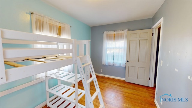 bedroom featuring baseboards and wood finished floors