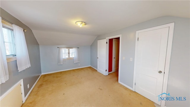 bonus room with light carpet, baseboards, and lofted ceiling