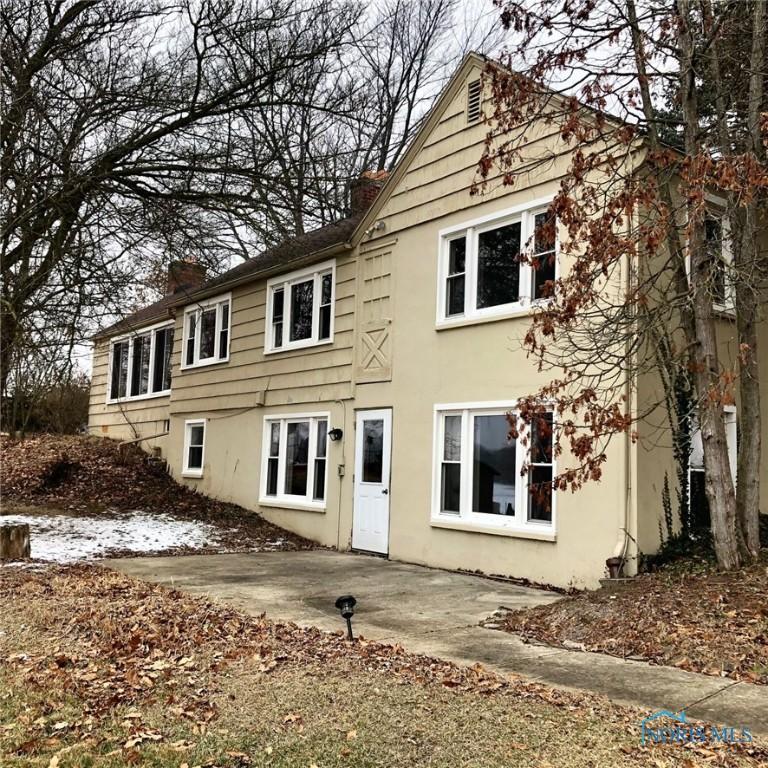 back of property featuring stucco siding, a patio, and a chimney