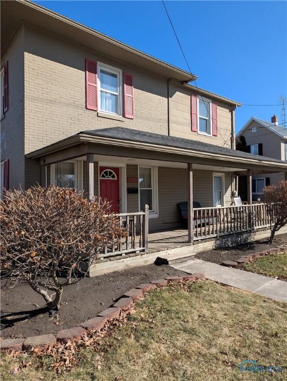 view of front of house with brick siding and a porch