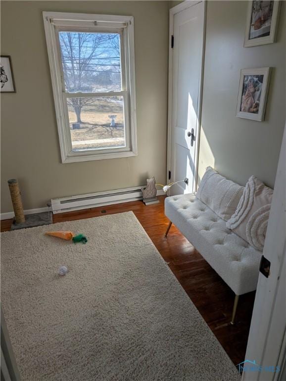 living area with baseboard heating and dark wood finished floors