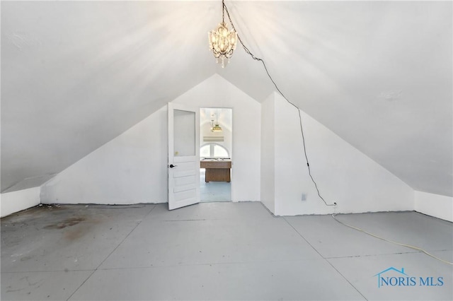 bonus room with a chandelier and vaulted ceiling