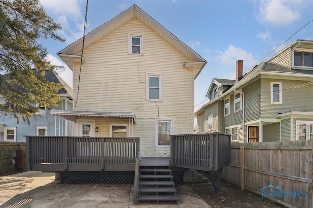 rear view of property featuring a wooden deck and fence