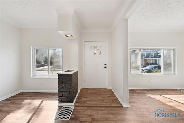 entryway featuring wood finished floors, visible vents, and baseboards