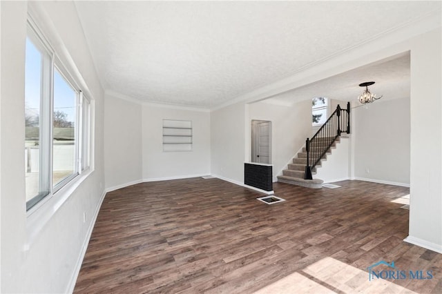 unfurnished living room with stairway, crown molding, baseboards, a chandelier, and dark wood-style flooring