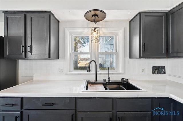 kitchen with a sink, tasteful backsplash, and light countertops