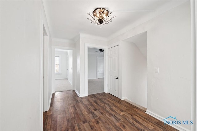 hallway with dark wood-type flooring and baseboards