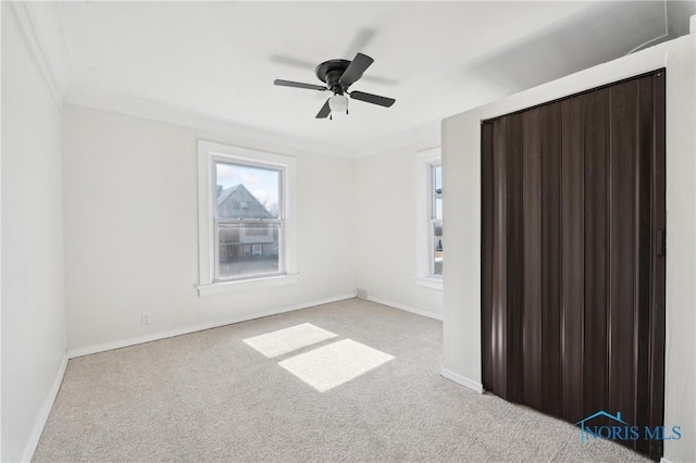 empty room with baseboards, carpet floors, and a ceiling fan