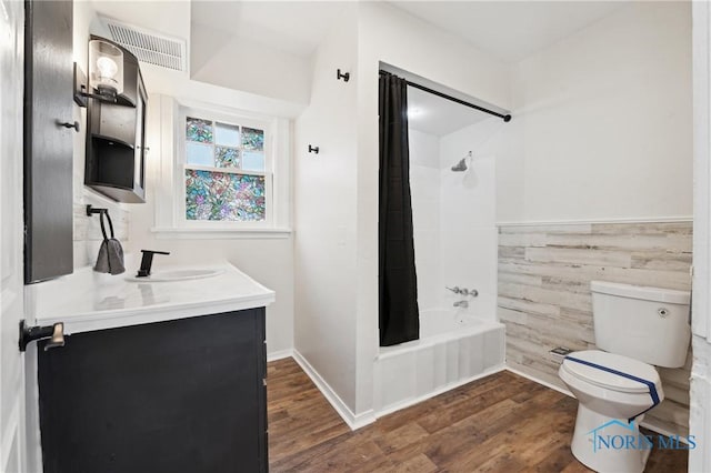 full bathroom featuring toilet, shower / bath combo, wood finished floors, and wainscoting