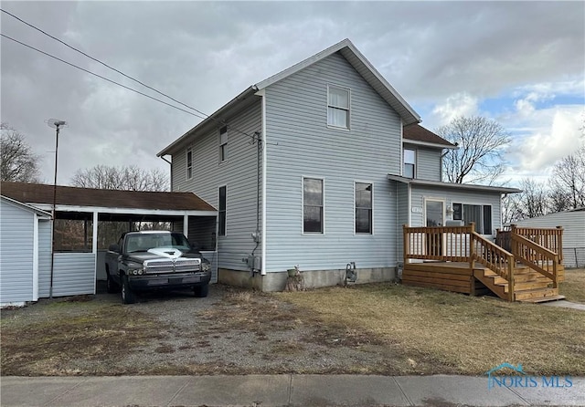 exterior space with a carport, driveway, and a wooden deck