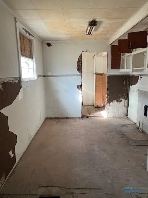 kitchen with unfinished concrete floors and a paneled ceiling