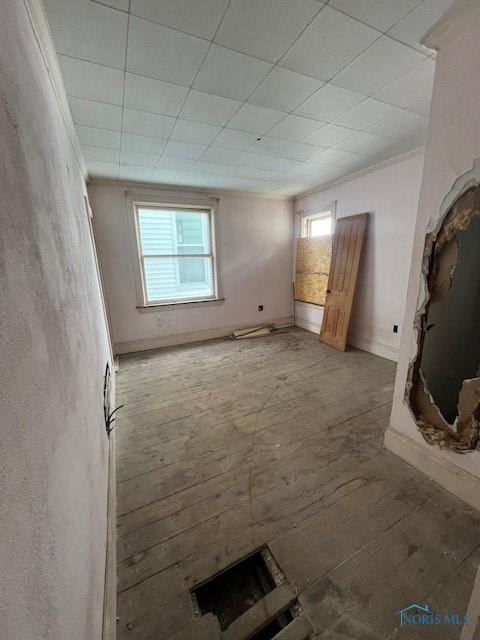 unfurnished living room featuring baseboards, a healthy amount of sunlight, and ornamental molding