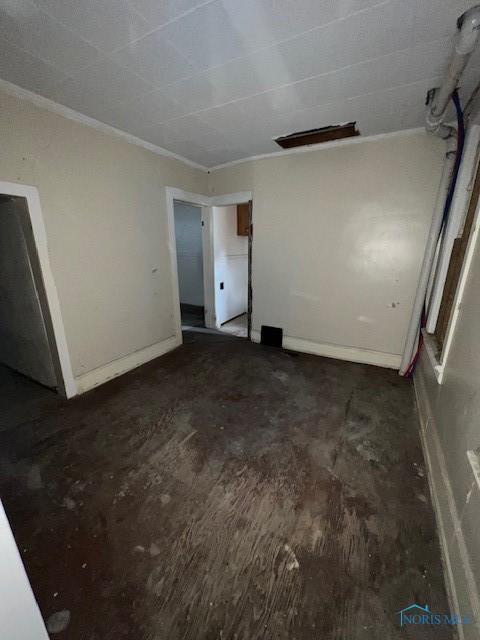 unfurnished room with baseboards and crown molding