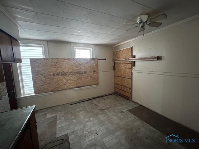 basement with a ceiling fan and light floors