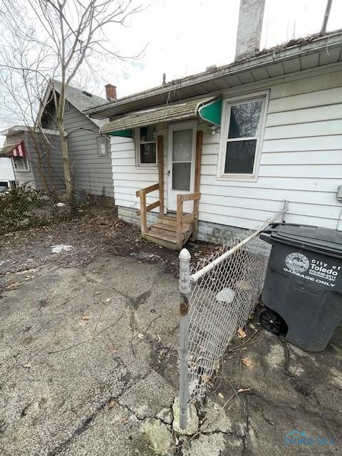 exterior space featuring a chimney and fence