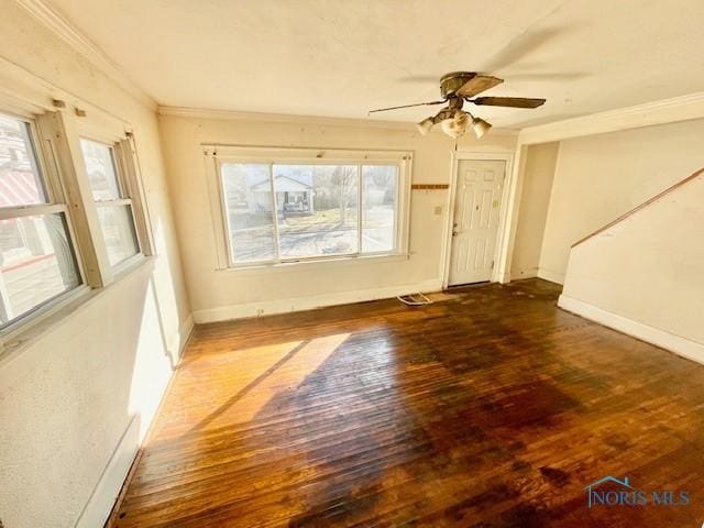 spare room with crown molding, hardwood / wood-style flooring, a ceiling fan, and baseboards