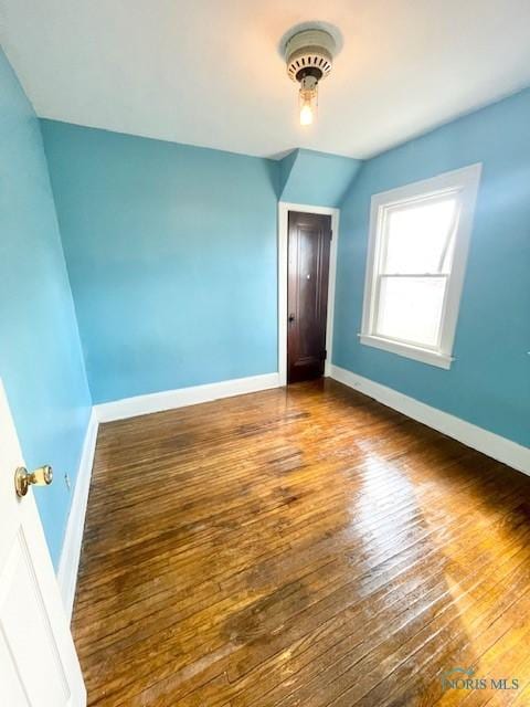 interior space featuring vaulted ceiling, baseboards, and wood-type flooring