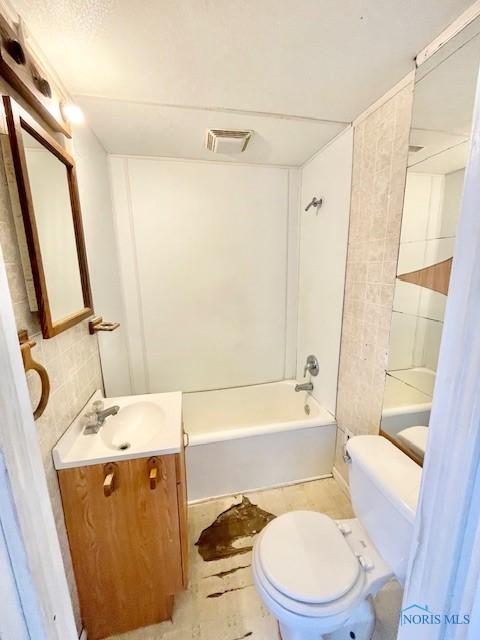 full bathroom with vanity, toilet, washtub / shower combination, and visible vents