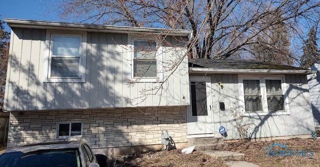 view of side of property with entry steps and stone siding