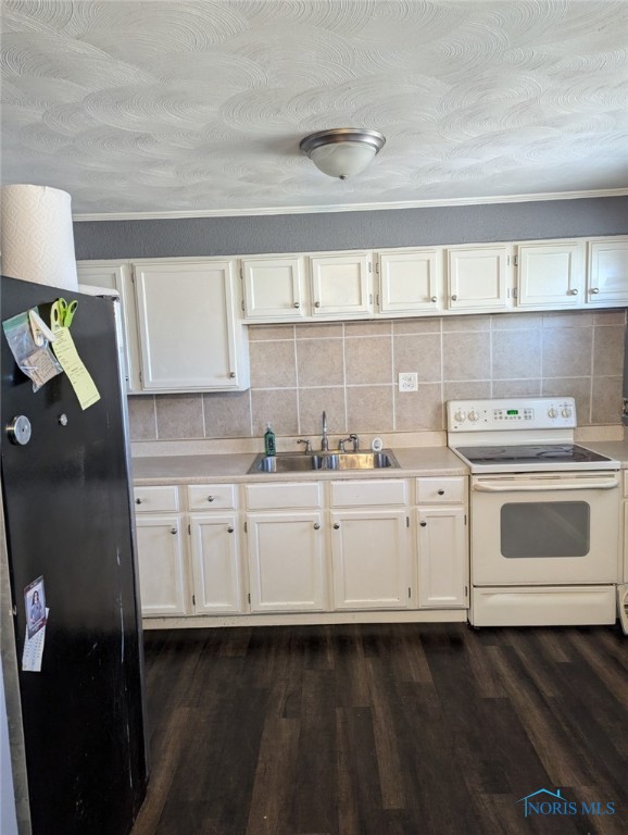 kitchen with freestanding refrigerator, a sink, dark wood-type flooring, light countertops, and white range with electric stovetop