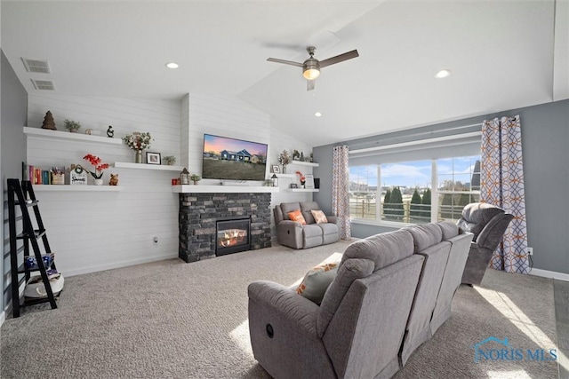 living room featuring visible vents, lofted ceiling, carpet floors, a stone fireplace, and a ceiling fan