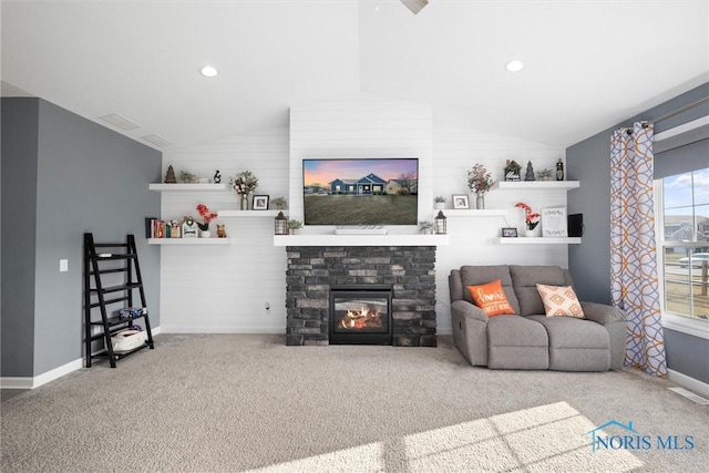 carpeted living area with visible vents, baseboards, lofted ceiling, a stone fireplace, and recessed lighting