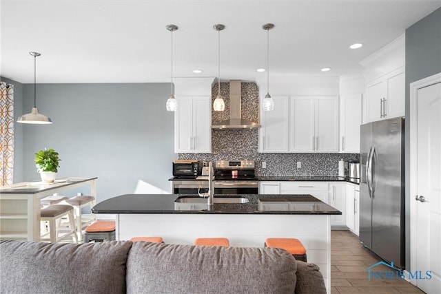 kitchen featuring stainless steel appliances, dark countertops, wall chimney exhaust hood, open floor plan, and backsplash