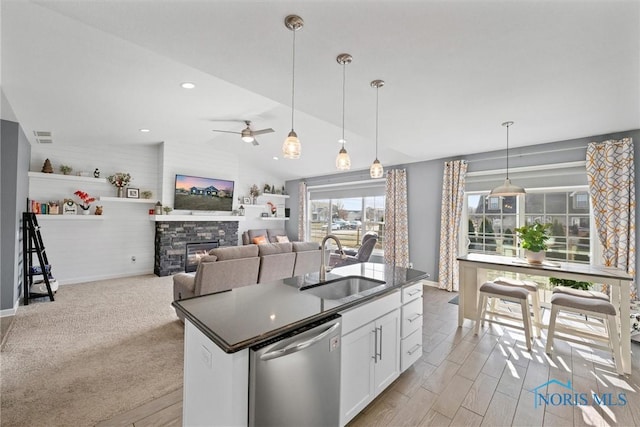 kitchen with a sink, dark countertops, dishwasher, and vaulted ceiling