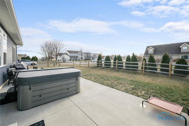 view of patio with a fenced backyard, a residential view, and a hot tub