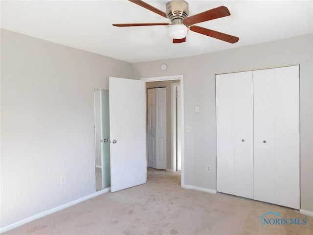 unfurnished bedroom with light colored carpet, baseboards, a closet, and ceiling fan