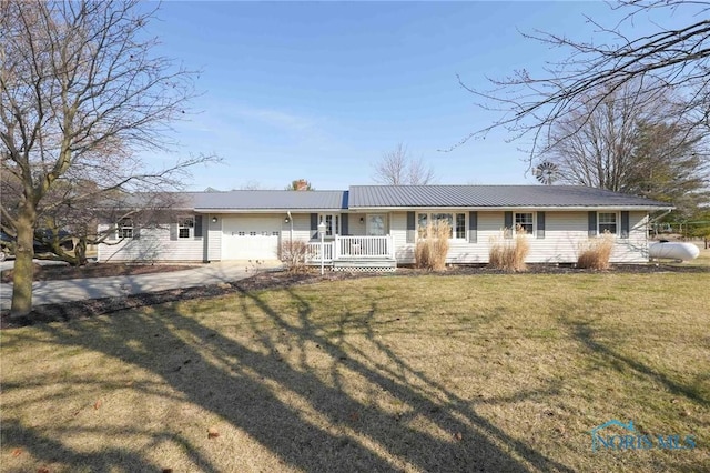 ranch-style home featuring driveway, covered porch, an attached garage, a front yard, and metal roof