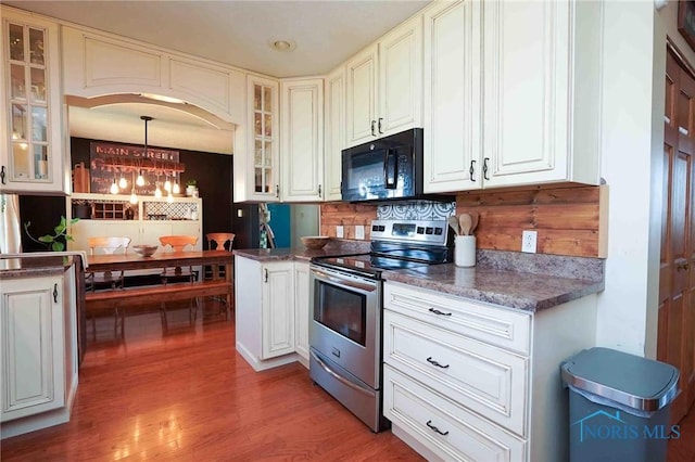 kitchen featuring stainless steel electric stove, glass insert cabinets, light wood-style floors, black microwave, and white cabinetry