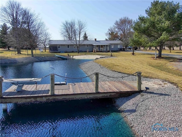 view of pool featuring a yard, a water view, and a dock