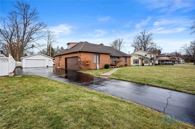 view of front facade featuring brick siding, a front lawn, fence, a garage, and an outbuilding