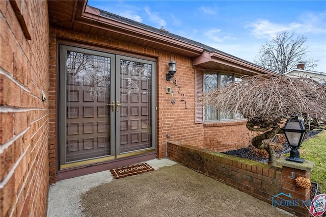 entrance to property featuring brick siding